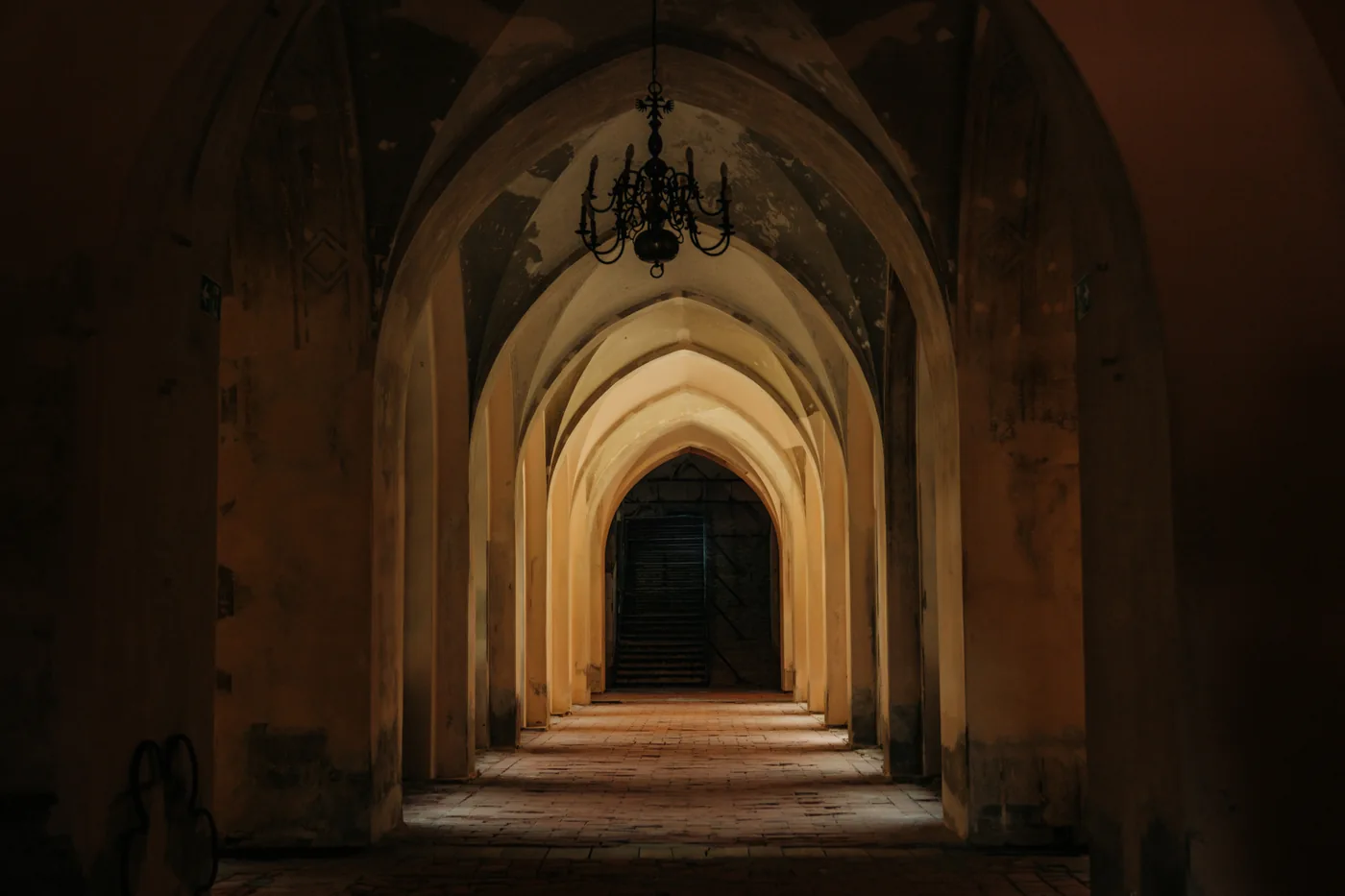 An ancient arched stone hallway with a moody gothic atmosphere