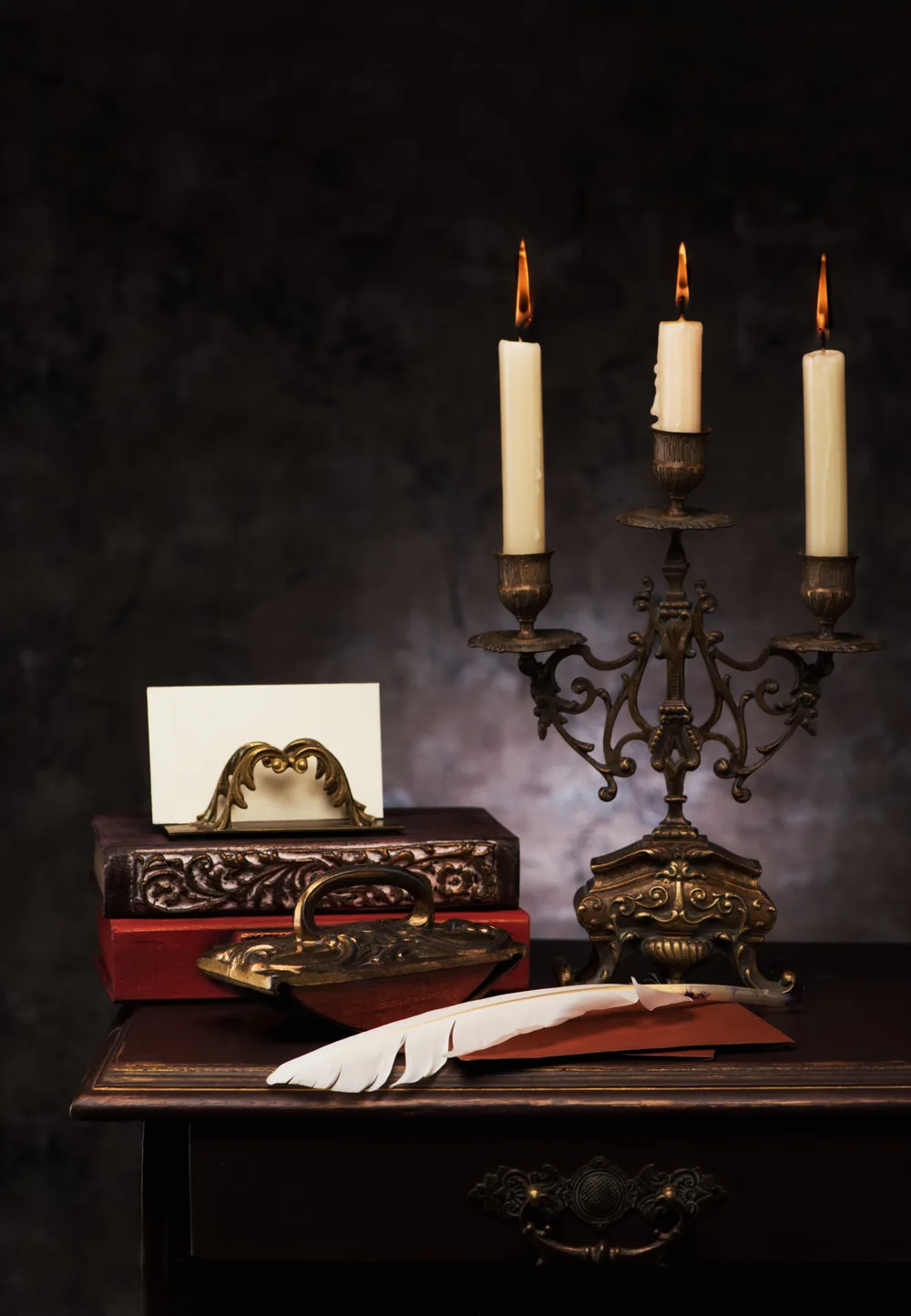 An elegant still life with candles and a quill pen